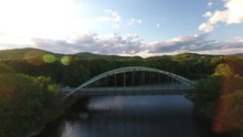 Aerial Video Of Green Steel Arch Bridges Over River At Sunset With Lens Flare