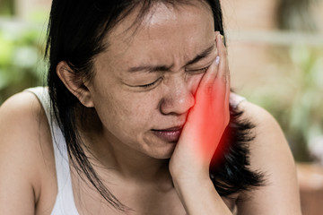 Temporomandibular Joint and Muscle Disorder: TMD concept. Woman hand on cheek face as suffering from facial pain or toothache