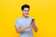 © Atstock Productions - Smiling young good looking Asian man using smartphone