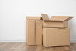 © New Africa - Pile of cardboard boxes near white wall indoors