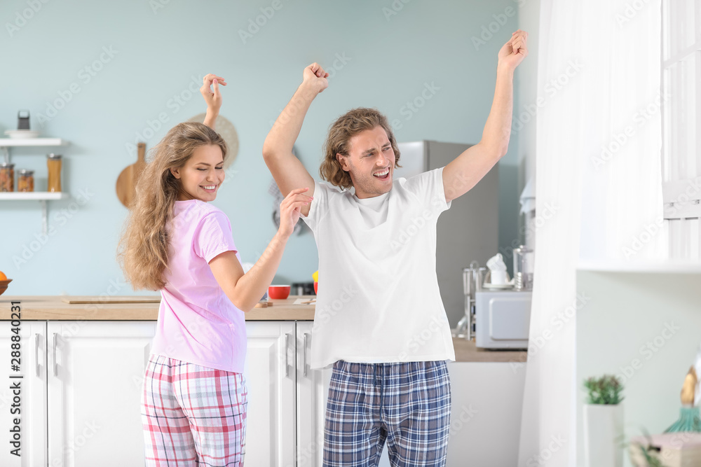 Happy young couple dancing in kitchen