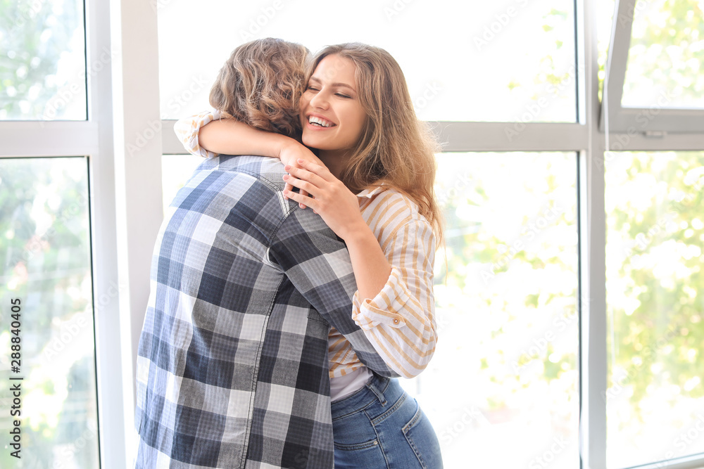 Happy young couple hugging at home