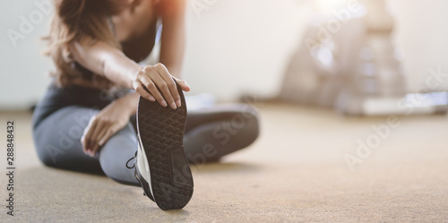 Fotografía Beautiful Asian woman with tan and slim body stretching legs before exercise