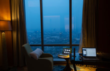 View Of Megapolis City From Inside A Hotel Room At Night. Amazing View Through Window.