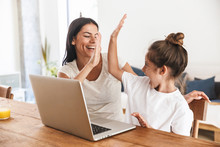Image Of Excited Family Woman And Her Little Daughter Giving High Five And Using Laptop Computer Together In Apartment