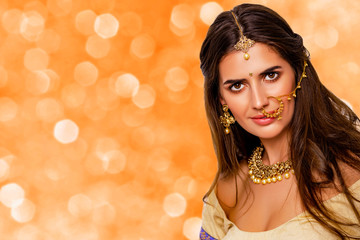 Portrait of beautiful indian girl. beauty portrait. isolated. orange background. Young hindu woman model with kundan jewelry set. Close up. Traditional India costume lehenga choli or sari. make-up   