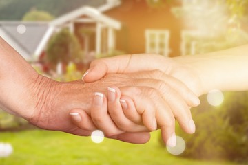 Wall Mural - Hands of the old man and a young woman on blurred your house