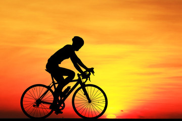 Wall Mural - Silhouette  Cycling  on blurry sunrise  sky   background.