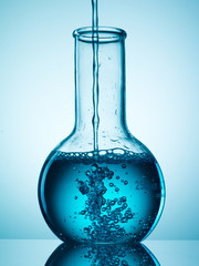 Wall Mural - different laboratory glassware with liquid and with reflection
