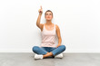 © luismolinero - Young blonde woman sitting on the floor touching on transparent screen