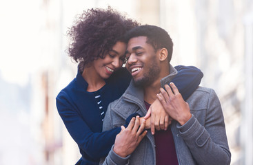 Wall Mural - Portrait of young african couple embracing on the street