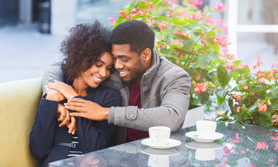 Wall Mural - Affectionate young couple cuddling in cafe during date