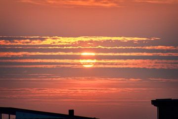 Wall Mural - red sunset over rooftop silhouette