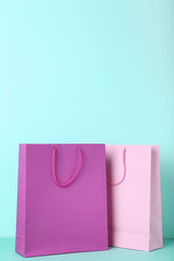 Wall Mural - Colorful paper shopping bags on mint background