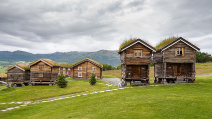 Wall Mural - Traditional wooden houses with roof covered with grass, plants and flowers in Oppdal in Norway, Scandinavia