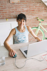 Sticker - Smiling woman with laptop working at home while looking camera