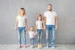 © Sunny studio - Happy family standing against grey background