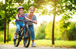 © JenkoAtaman - happy family mother teaches child daughter to ride a bike in the Park