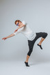 © Smeilov - Red-haired man in sunglasses and a white t-shirt dancing on a light background