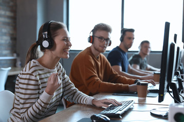 Wall Mural - Group of people playing video games in internet cafe