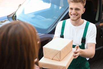 Sticker - Young delivery courier giving parcels to customer outdoors