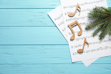 Wall Mural - Christmas tree branch, notes and music sheets on blue wooden table, flat lay with space for text