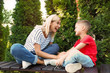 © New Africa - Nanny with cute little boy on bench outdoors