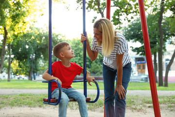 Sticker - Nanny and cute little boy on swing in park