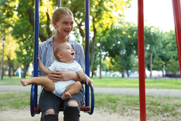 Sticker - Teen nanny with cute little baby on swing outdoors. Space for text