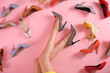 Woman and different high heel shoes on pink background, top view