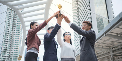 group of businesspeople giving away trophies to confirm the success of the increased sales in the ou