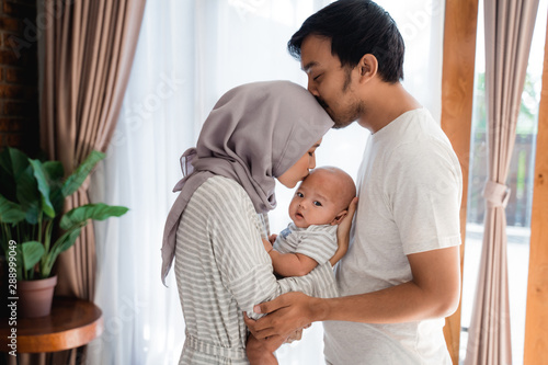 Cuadros en Lienzo muslim parent kissing together with baby boy at home
