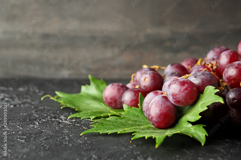 Ripe sweet grapes on dark table