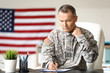 © Pixel-Shot - Mature male soldier writing report in headquarters building
