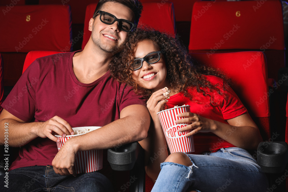 Couple with popcorn watching movie in cinema