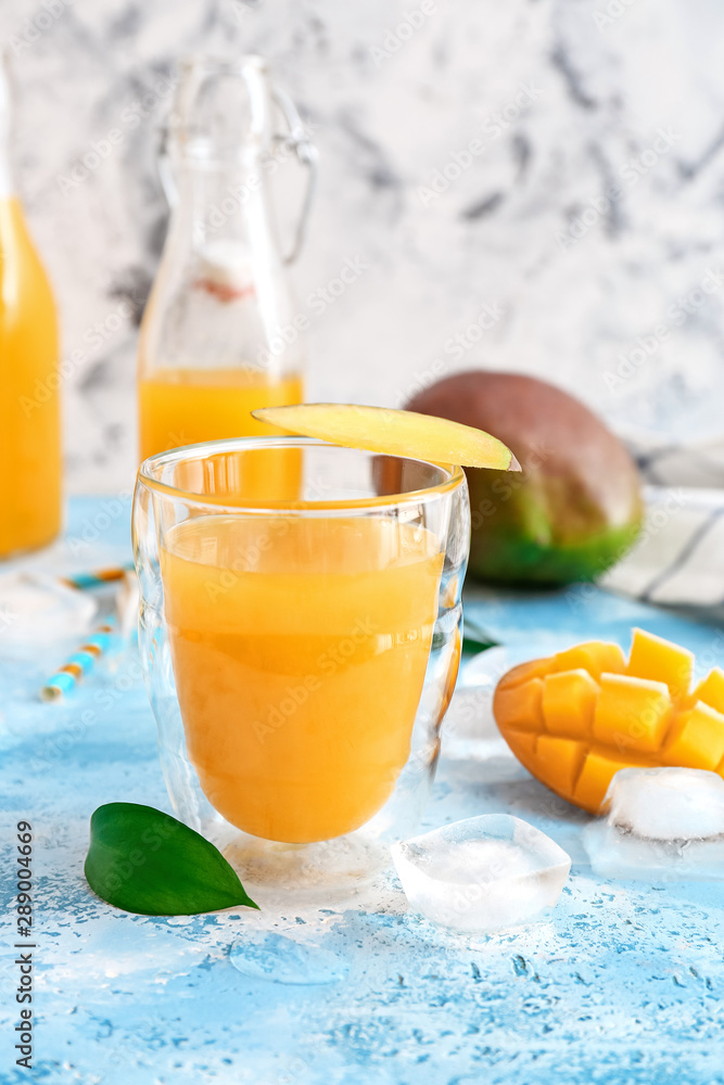 Glass of fresh mango juice on table