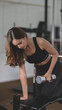 © bongkarn - Beautiful asian athletic woman lifting weights at the gym