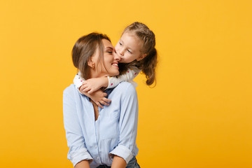 Woman in light clothes have fun with cute child baby girl 4-5 years old. Mommy little kid daughter isolated on yellow background studio portrait. Mother's Day love family parenthood childhood concept.