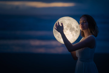 Wall Mural - tender image of a girl. female magic. beautiful attractive girl on a night beach with sand hugs the 