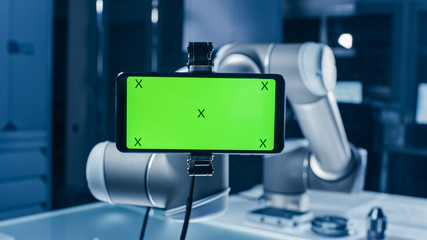 Aufkleber - Robot Arm Holding Green Mock-up Screen Smartphone in Landscape Mode. Industrial Robotic Manipulator End Effector Holds Mobile Phone with Chroma Key Display. 