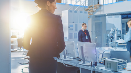 Wall Mural - Shot of Stylish Female Engineer Enters Bright Modern Research Facility and Joins Team of other Robot and IT Specialists