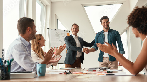 Fotomural Good job Two cheerful colleagues shaking hands and smiling while having a meetin