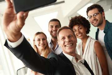 Successful team Group of smiling colleagues taking selfie while standing in the modern office