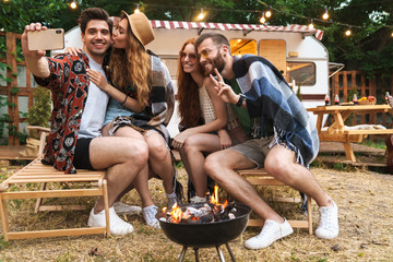 Canvas Print - Group of cheerful happy friends sitting at the trailer