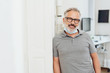 © contrastwerkstatt - Relaxed dentist leaning against a surgery wall