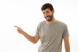 © SB Arts Media - Charming smiling young man pointing finger at empty copy space for advertisement