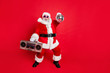 © deagreez - Full length photo of cheerful santa claus in headwear hat holding boom box glittering ball dancing on newyear party wearing style stylish eyeglasses eyewear isolated over red background