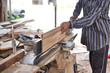 © phoderstock - Carpenter planing wood surface with planer machine. Woodworking tools and technology.