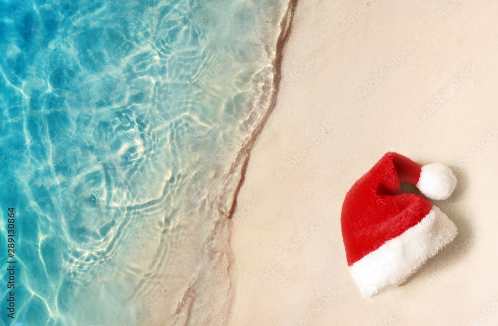 Christmas holidays concept. Top view of santa claus hat on summer sand ...