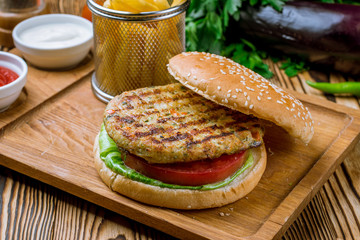 Wall Mural - Burger with chicken and fries with sause on the board